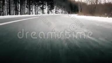 低角度视角：汽车快速行驶穿过冰冻森林道路